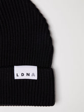 Load image into Gallery viewer, Close up of LDNA logo on the LDNA London black fisherman style beanie.
