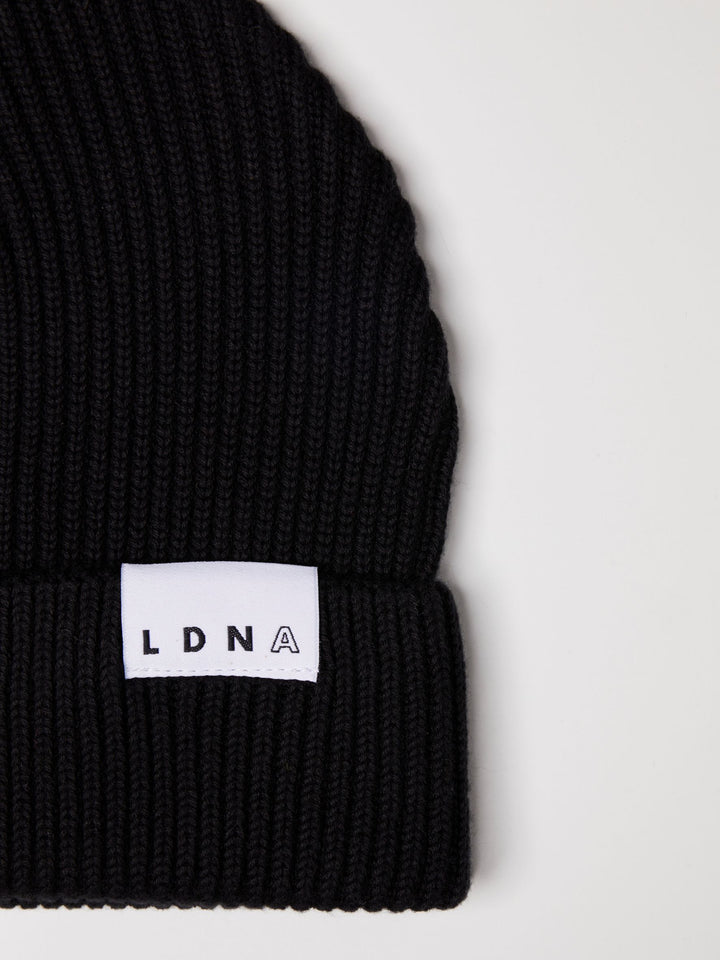 Close up of LDNA logo on the LDNA London black fisherman style beanie.